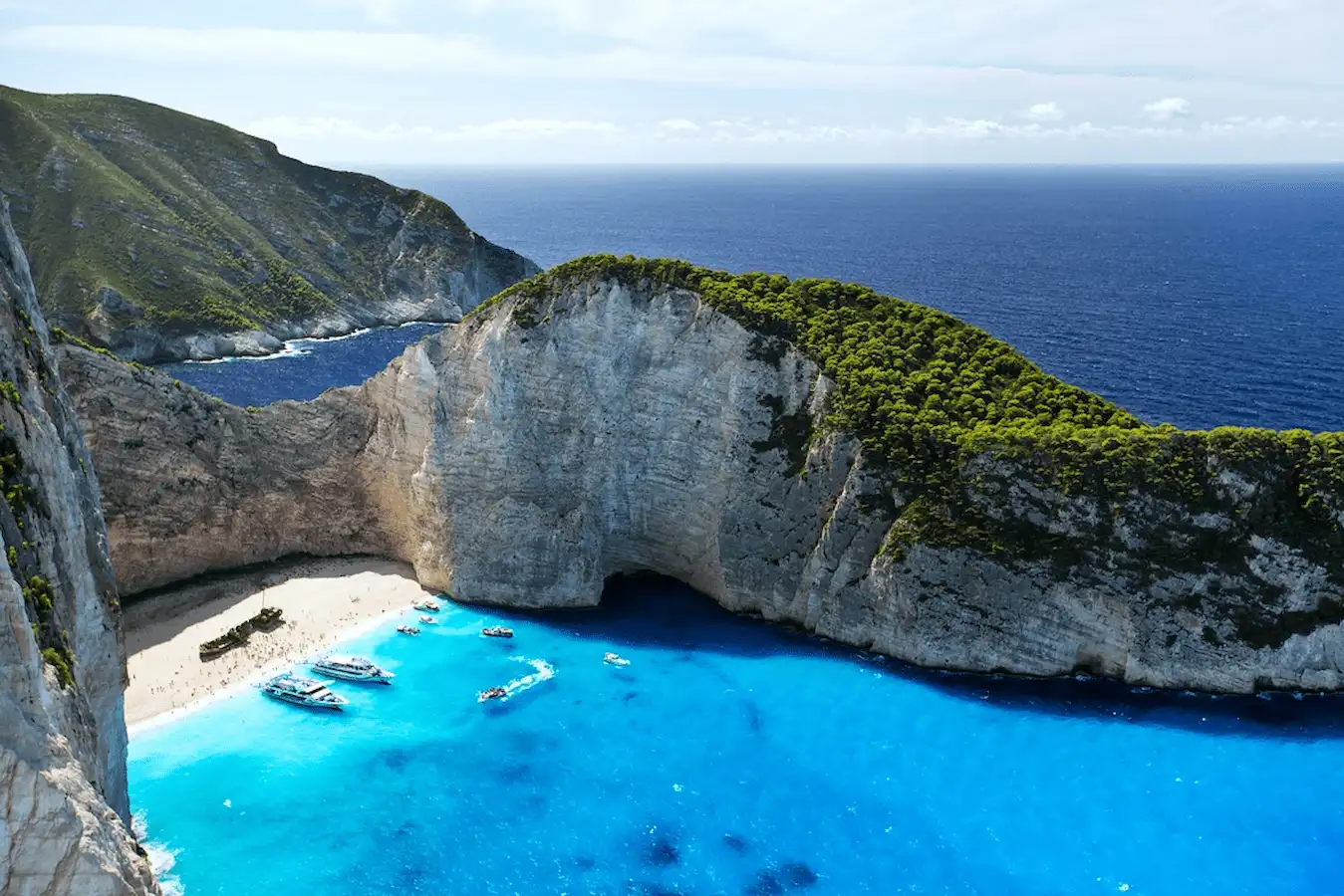 Eine stilvolle Segelyacht, die in einer ruhigen Bucht in der Ägäis vor Anker liegt, mit griechischen Inseln im Hintergrund.