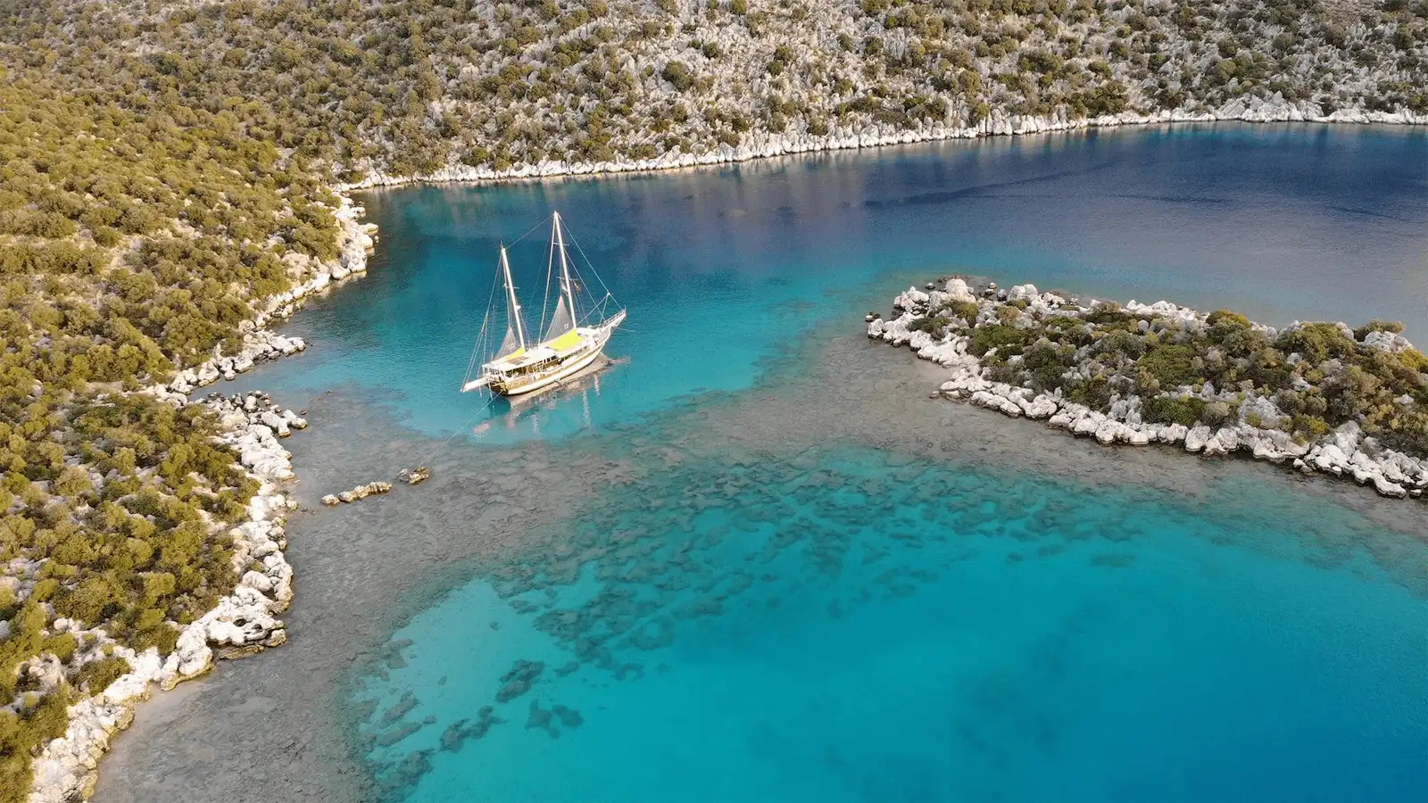 Eine Segelyacht, die auf dem türkisfarbenen Wasser von Kekova schwimmt.