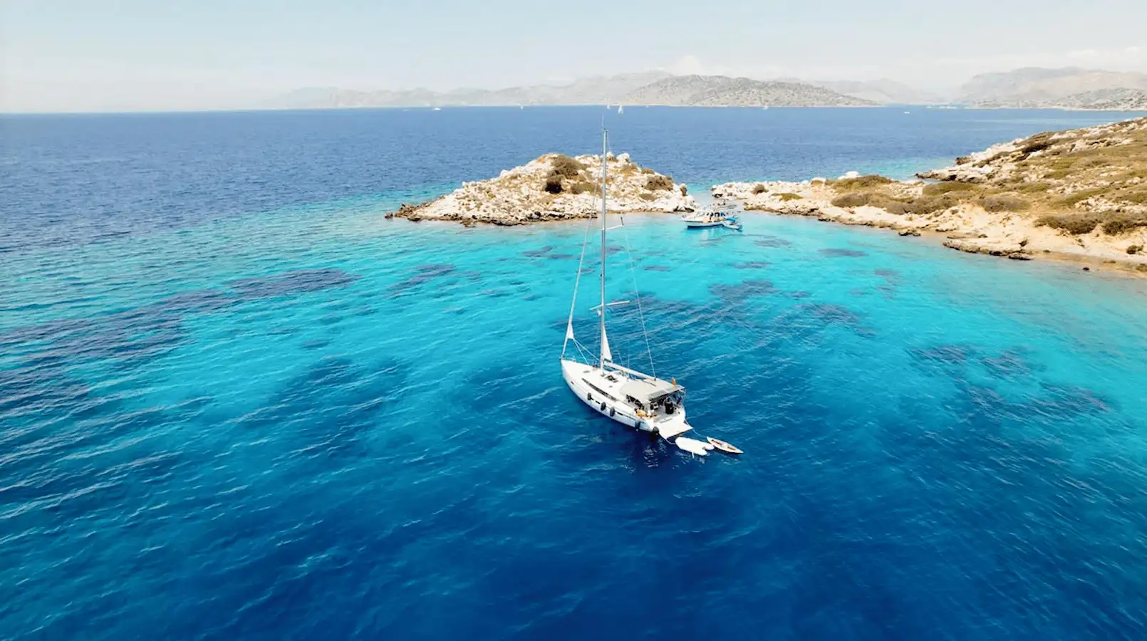 Eine luxuriöse Segelyacht, die in einer von Pinienbäumen umgebenen Bucht in Marmaris vor Anker liegt.