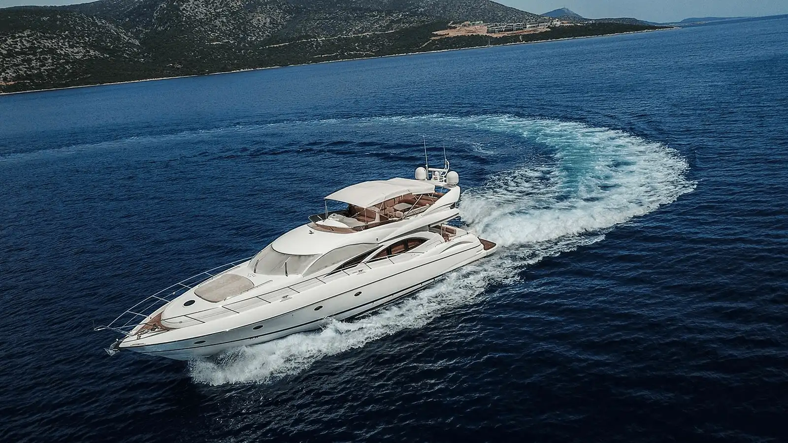 Eine Luxusyacht, die in einer türkisfarbenen Bucht an der türkischen Riviera vor Anker liegt.